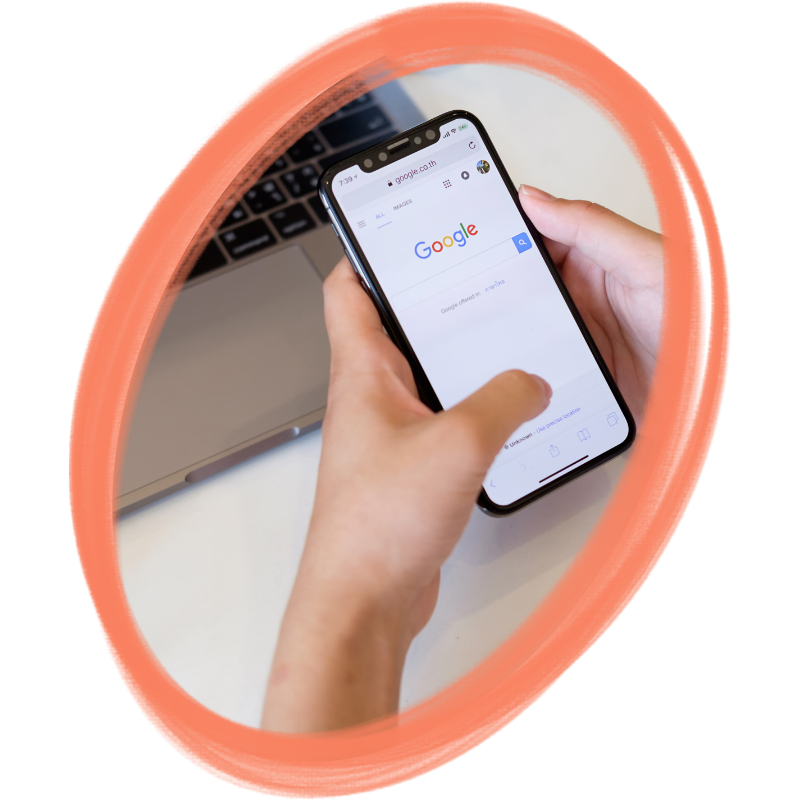 image d'une main qui tient un téléphone dans un cadre en ovale - illustration de la page accompagnement en référencement naturel